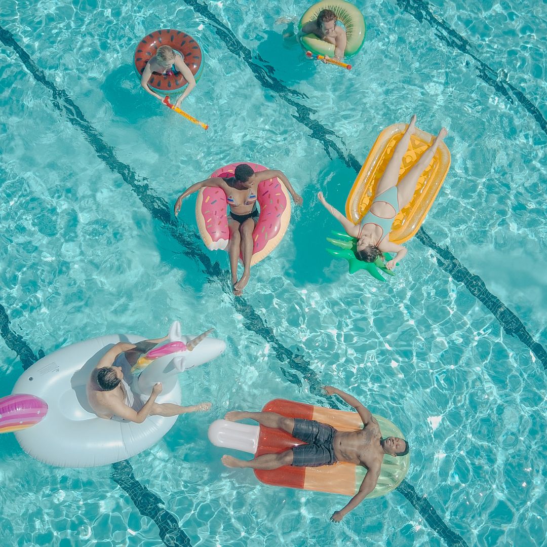 People relaxing and floating in a pool